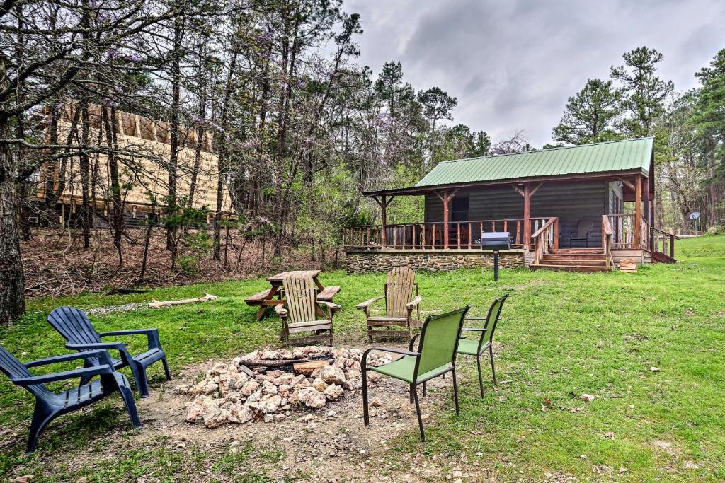a group of chairs around a fire pit in front of a cabin at Rustic Cabin with Hot Tub Near Broken Bow Lake! in Broken Bow
