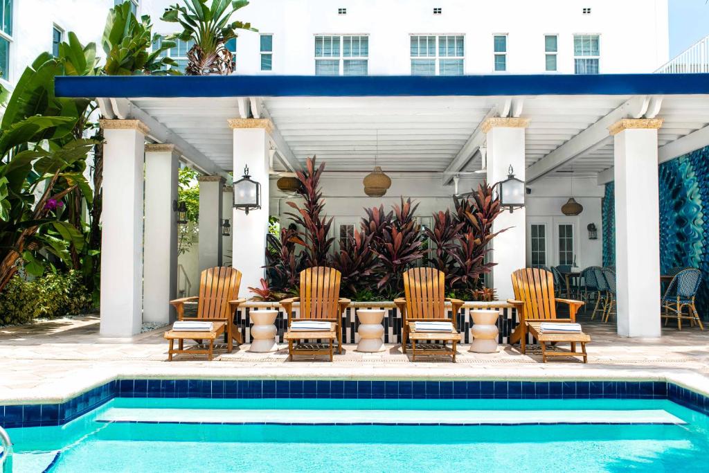 a patio with chairs and a table next to a pool at Blue Moon Hotel in Miami Beach