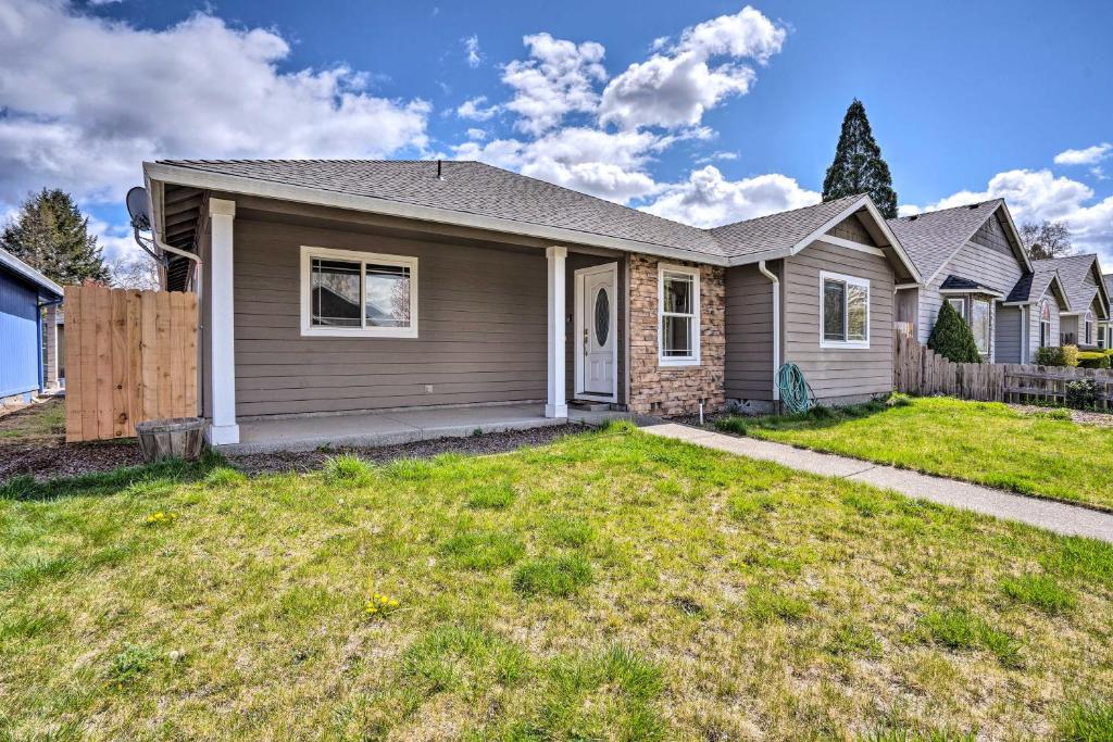 a house with a grass yard in front of it at Grants Pass Home 1 Mi to Downtown and Rogue River! in Grants Pass