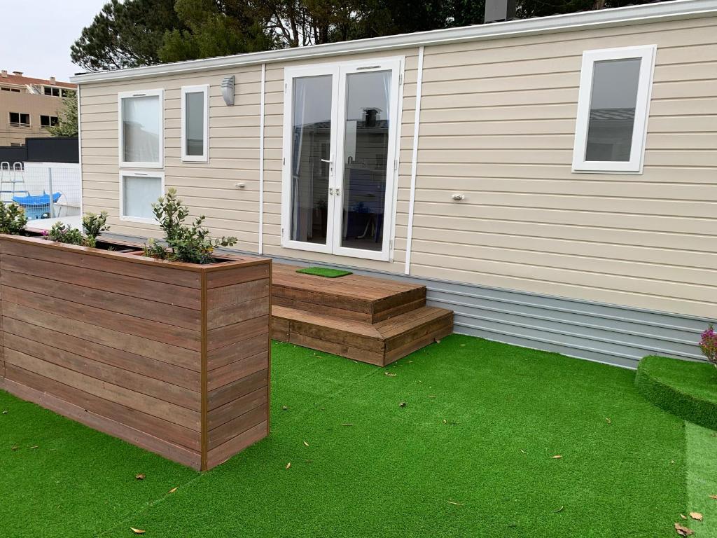 a backyard with a deck and a house with green grass at Villa Granja Sol in São Félix da Marinha