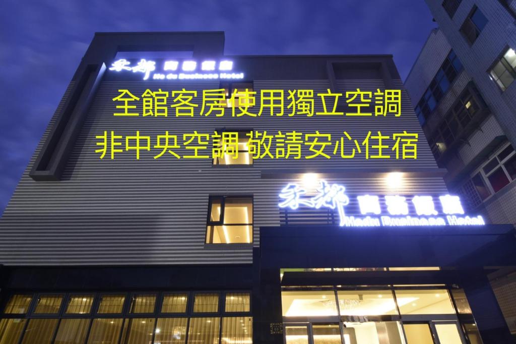 a building with a sign on the side of it at Hedu Hotel in Beigang