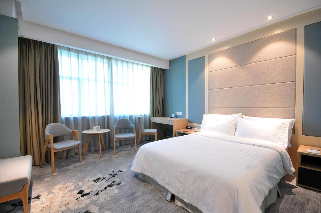 a hotel room with a bed and a table and chairs at Gubei Garden Hotel Shanghai Hongqiao in Shanghai
