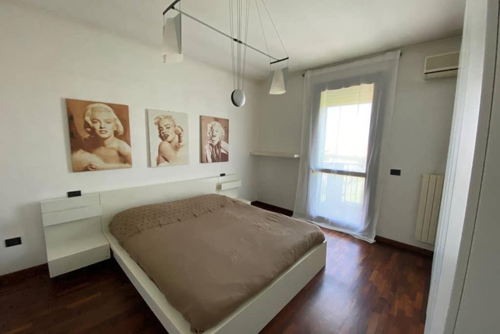1 dormitorio con 1 cama con cuadros en la pared en Appartamento Girasole tra Padova e Venezia, en Fiesso dʼArtico