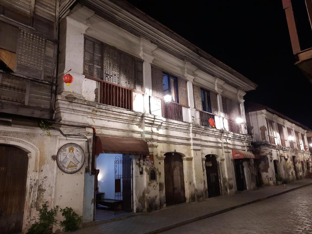 een oud gebouw met een klok aan de straatkant bij Escolta's Homey Lodge in Vigan