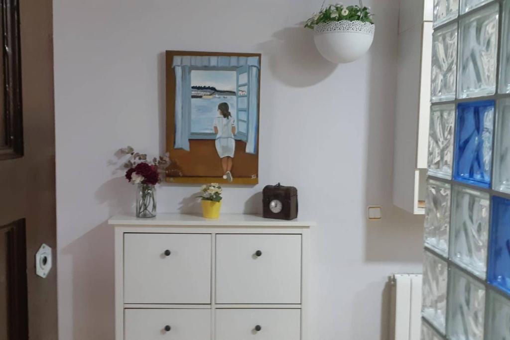 a white dresser in a room with a picture on the wall at Cozy Apartment Near The Beach in Barcelona