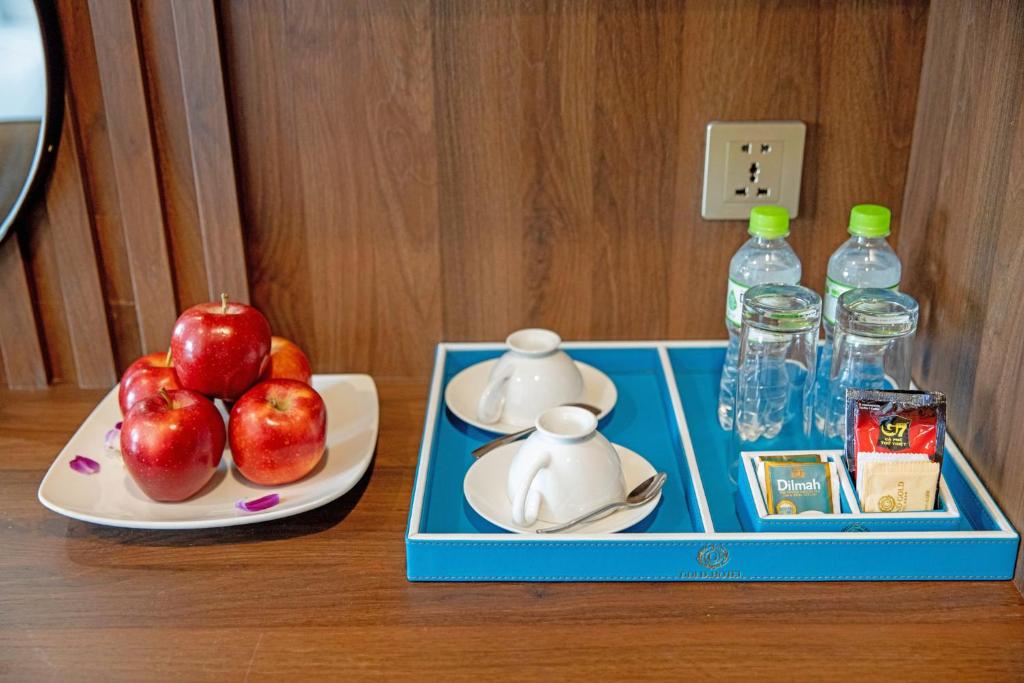 An in-room tray with apples, tea service and bottled water.