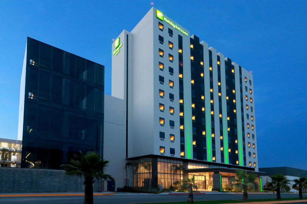 un bâtiment d'hôtel avec un panneau sur son côté dans l'établissement Holiday Inn & Suites - Monterrey Apodaca Zona Airport, an IHG Hotel, à Monterrey