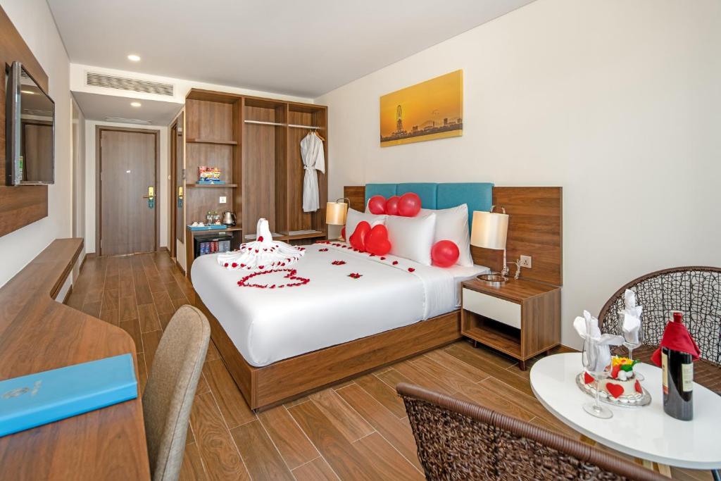 A furnished bedroom with a large decorated bed, storage and a small seating area.