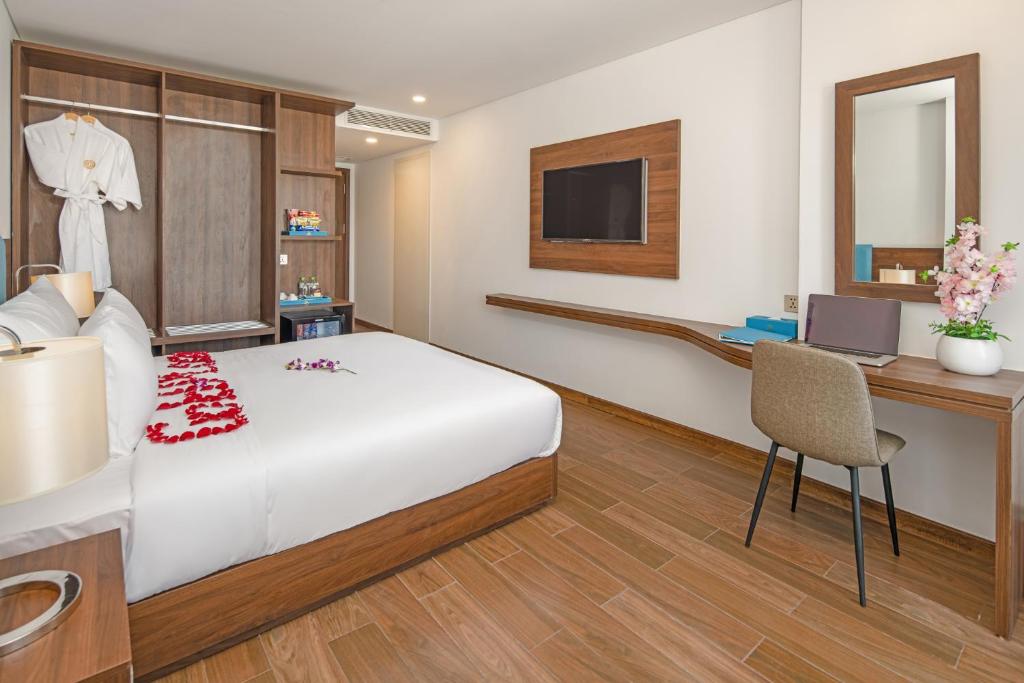 A contemporary bedroom with a wall-mounted television and compact dressing desk.