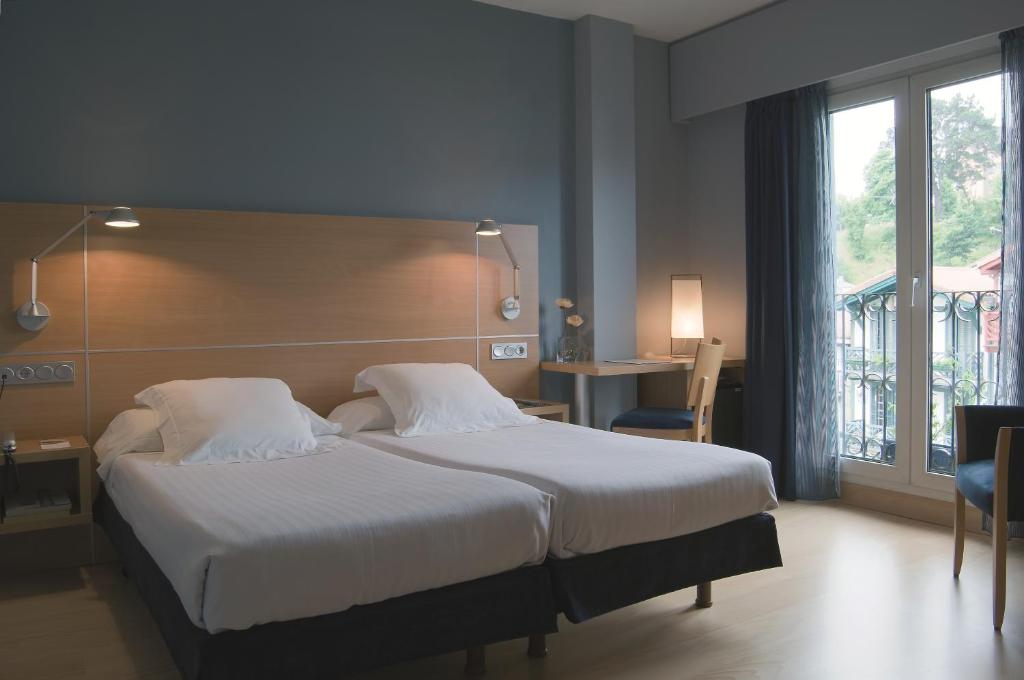 Postel nebo postele na pokoji v ubytování Hotel Jauregui