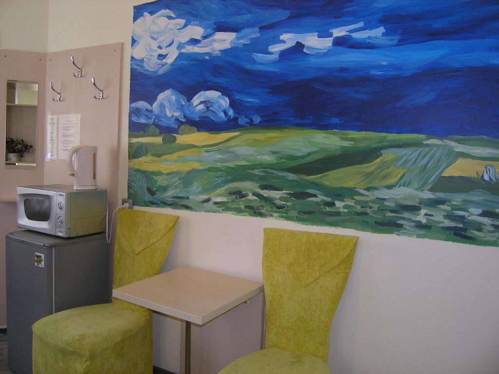 una habitación con una mesa y dos sillas y una pintura en Art Villa on Sumskaya Street, en Járkov