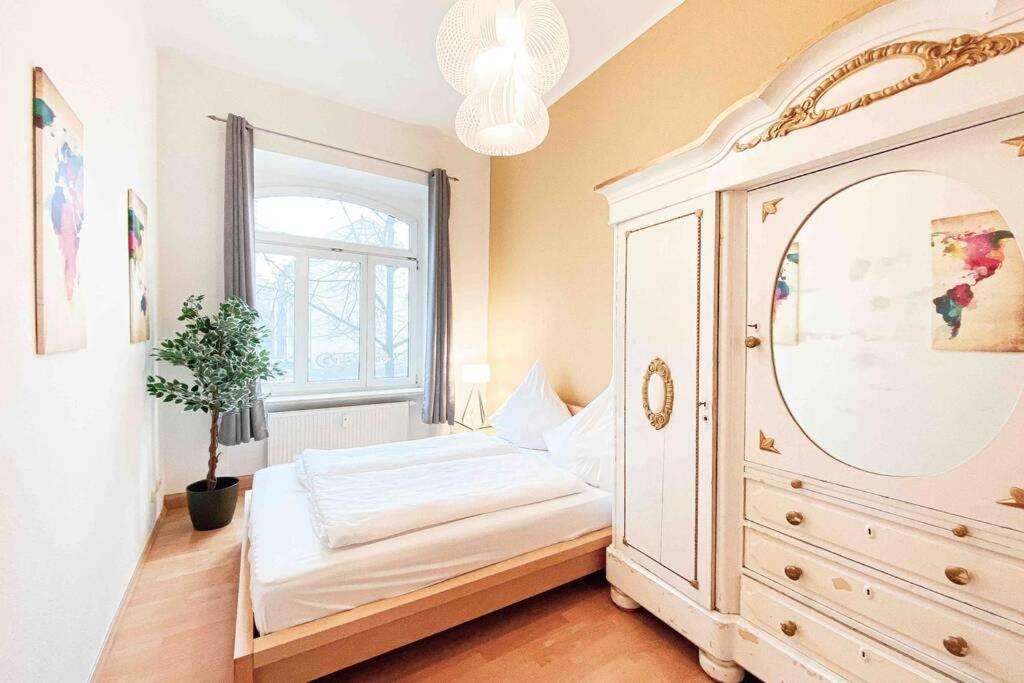 a bedroom with a bed and a window and a dresser at Altbauwohnung direkt an der Karli mit Balkon - Netflix inklusive in Leipzig