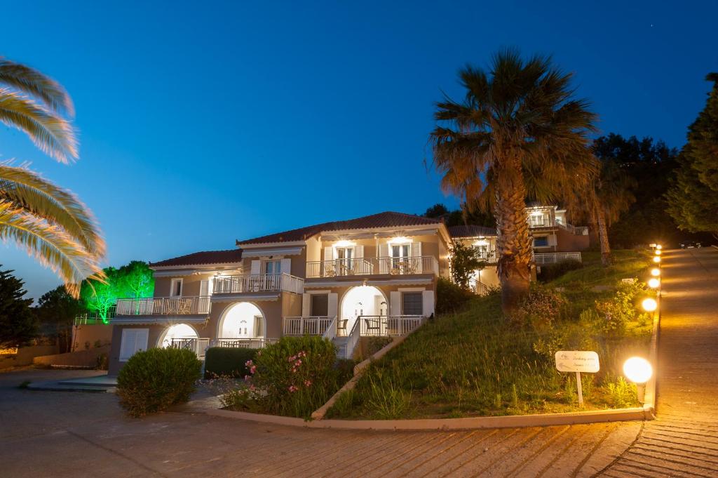 a large house with palm trees in front of it at Iliovasilema in Platy