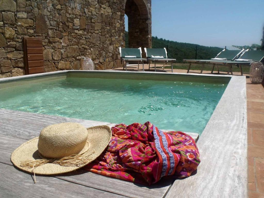 un cappello e una coperta accanto alla piscina di Il LUPONE a Porto Azzurro
