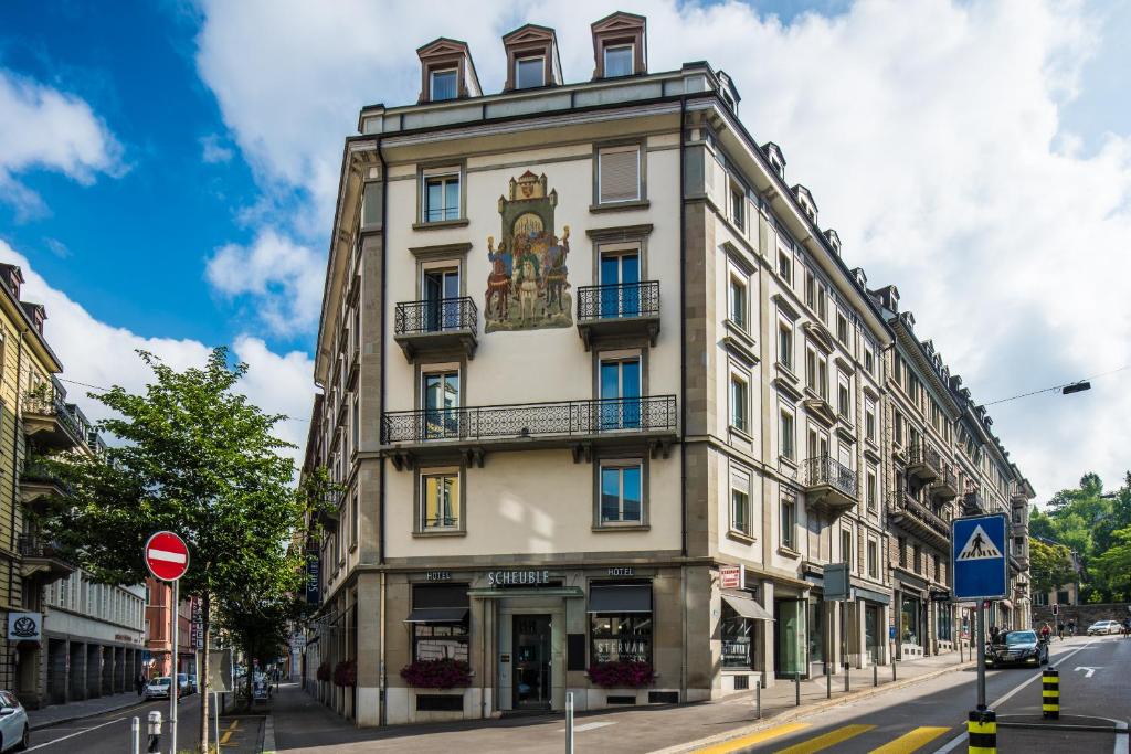 a tall building with a clock on the side of it at Hotel Scheuble in Zürich