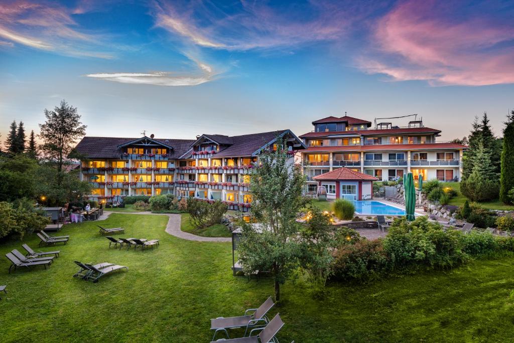 un gran edificio con un patio con bancos y una piscina en Dein Engel en Oberstaufen