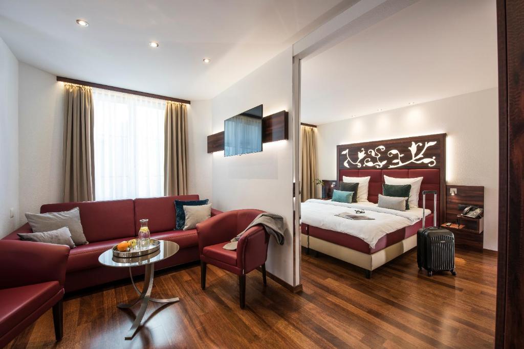a hotel room with a bed and a couch at Hotel Scheuble in Zürich