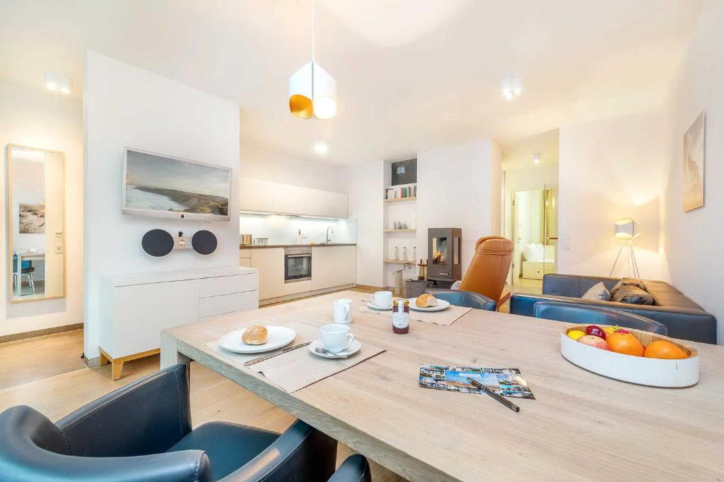 ein Wohnzimmer mit einem Holztisch und blauen Stühlen in der Unterkunft die Strandvilla Nordlicht in Ostseebad Sellin