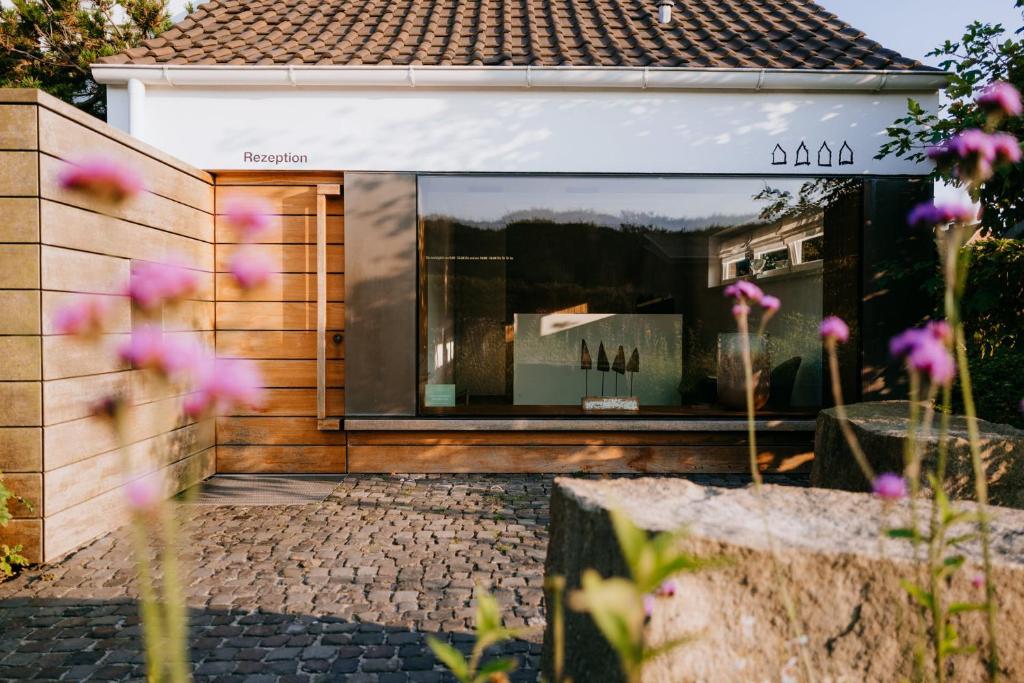 a house with a large window in a garden at Vier Häuser in Norderney