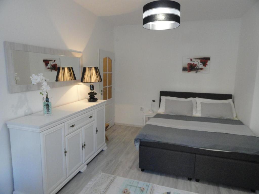 a bedroom with a bed with two lamps and a dresser at Apartmán Sluka in Jilemnice