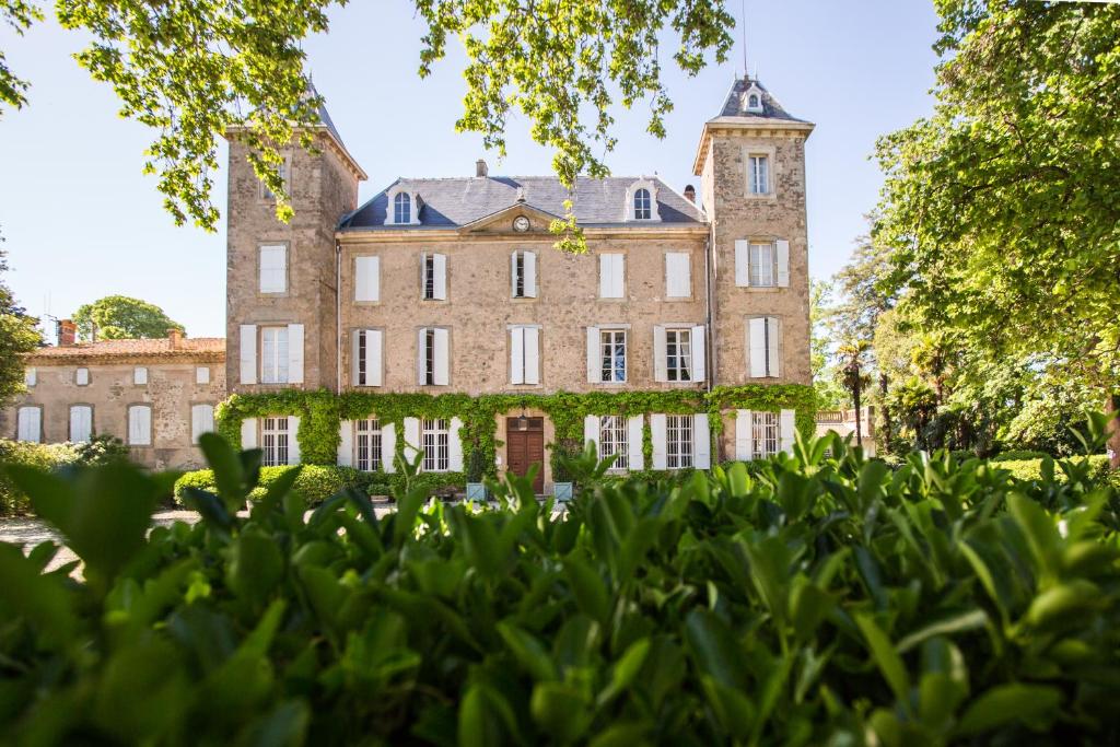 a large brick building with a tower at Chateau de Blomac in Blomac