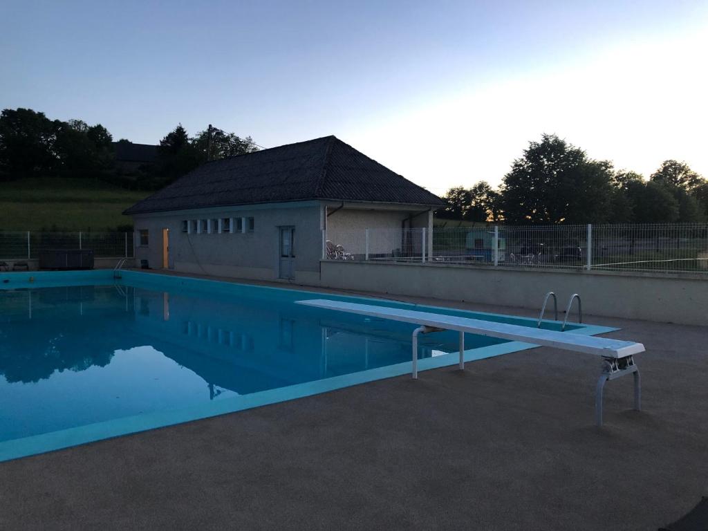 une grande piscine en face d'un bâtiment dans l'établissement La Vie Belle, à Bassignac-le-Haut