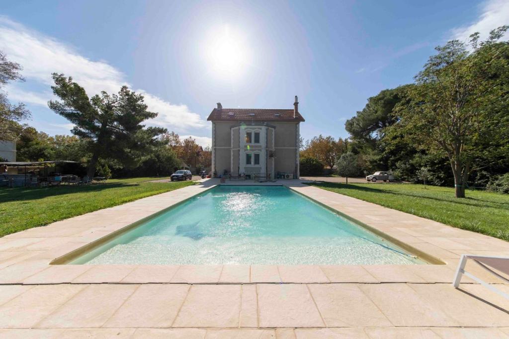 a swimming pool in front of a house at Maébrilu Camargue Provence in Salin-de-Giraud