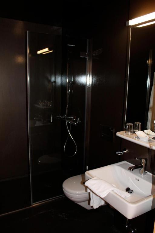 a bathroom with a shower and a toilet and a sink at Ospizio San Gottardo in Airolo