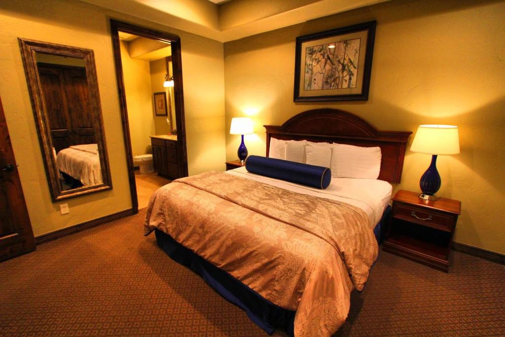 a hotel room with a bed and a mirror at Canyon Villas at Coral Ridge in Washington