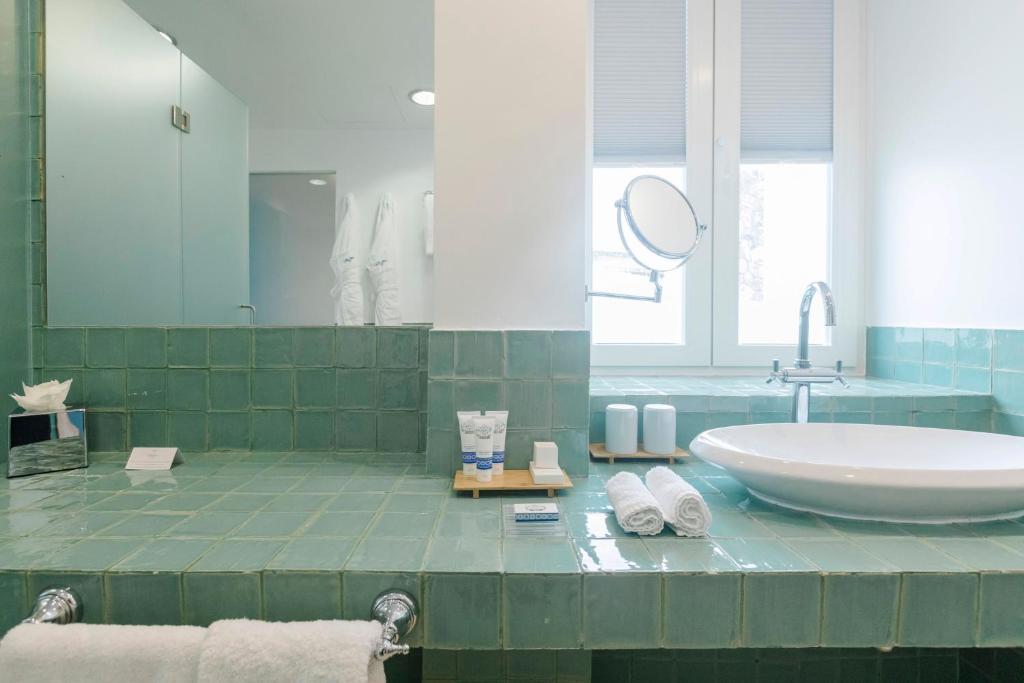 a bathroom with a large tub and a sink at The Albatroz Hotel in Cascais