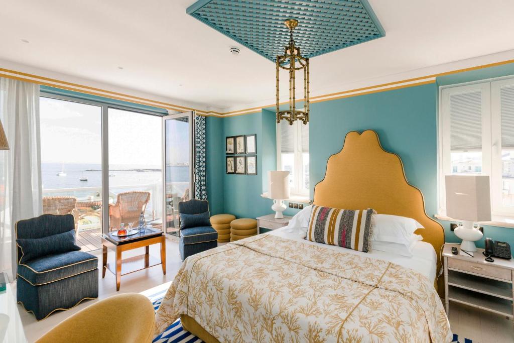 a bedroom with a bed and a view of the ocean at The Albatroz Hotel in Cascais