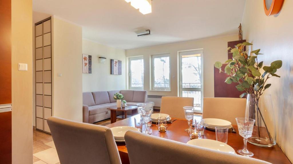 a dining room with a wooden table and chairs at VacationClub - Gryfa Pomorskiego 77D Apartament 34A in Międzyzdroje