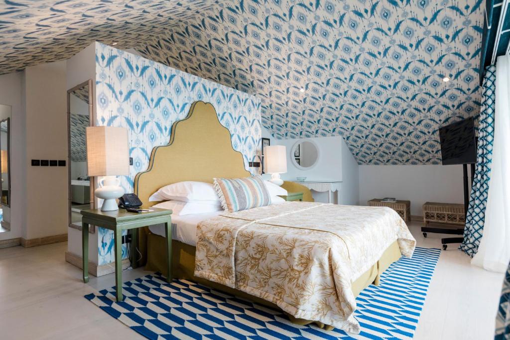 a bedroom with a bed and a blue and white wallpaper at The Albatroz Hotel in Cascais