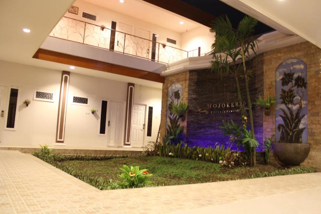 a house with a courtyard and a balcony at Mojokerto Classic Homestay in Mojokerto