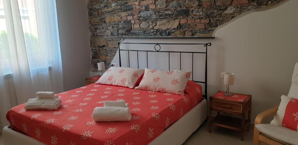 um quarto com uma cama vermelha e toalhas em Appartamenti Mondo Per Te em Santa Margherita Ligure