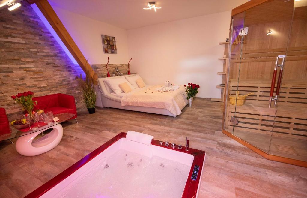 uma casa de banho com banheira e uma cama num quarto em Romantický wellness suite hotel Heinz em Dobris