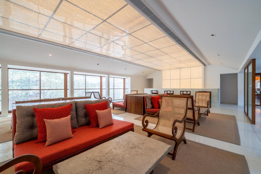 a living room with a red couch and chairs at Cinnamon Bentota Beach - Signature Selection in Bentota