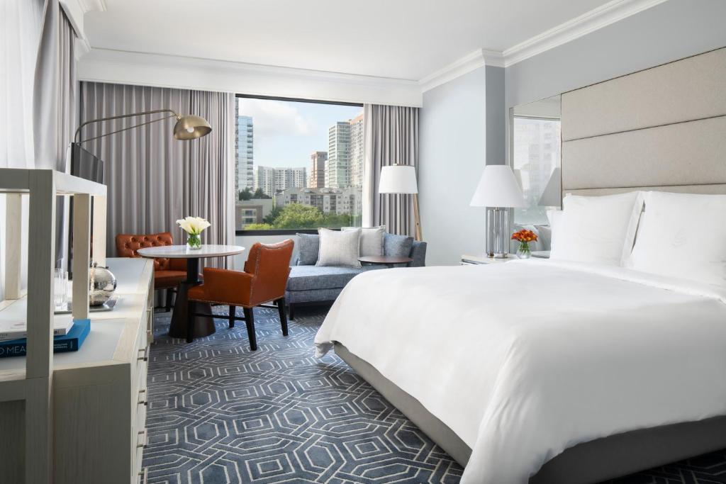 a hotel room with a large bed and a living room at Four Seasons Hotel Atlanta in Atlanta