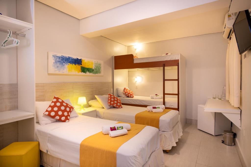 a hotel room with two beds and a mirror at Brazilodge All Suites Hostel in Sao Paulo