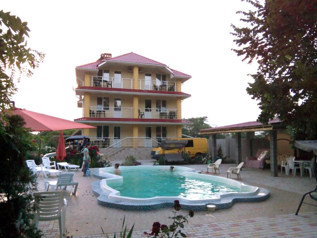 a large swimming pool in front of a building at Mini-Dacha in Kurortne