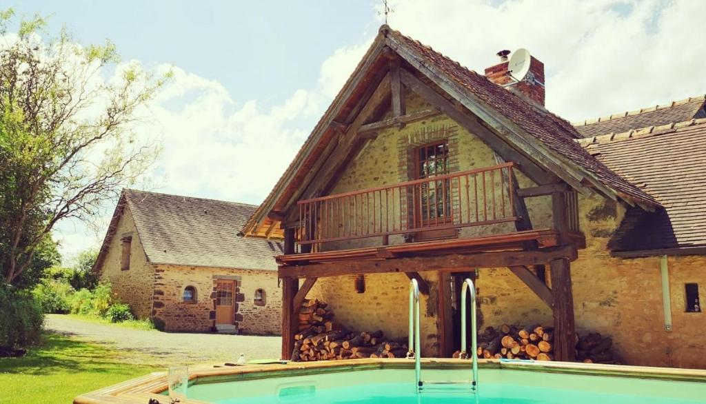 a house with a deck next to a swimming pool at 24H Le Mans - Les Haies Gite, near Le Mans Circuit in Coulans-sur-Gée