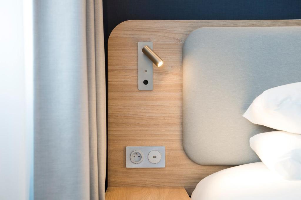 a close up of a door to a bed at Holiday Inn Express - Paris - CDG Airport by IHG in Roissy-en-France