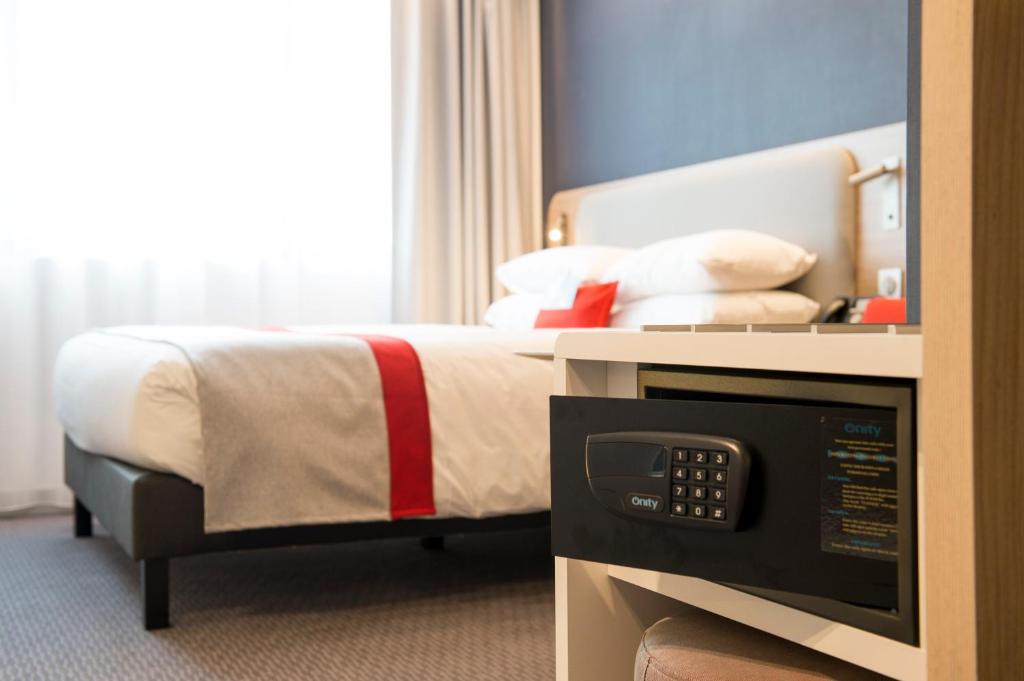 a bedroom with a bed with a television in it at Holiday Inn Express - Paris - CDG Airport by IHG in Roissy-en-France