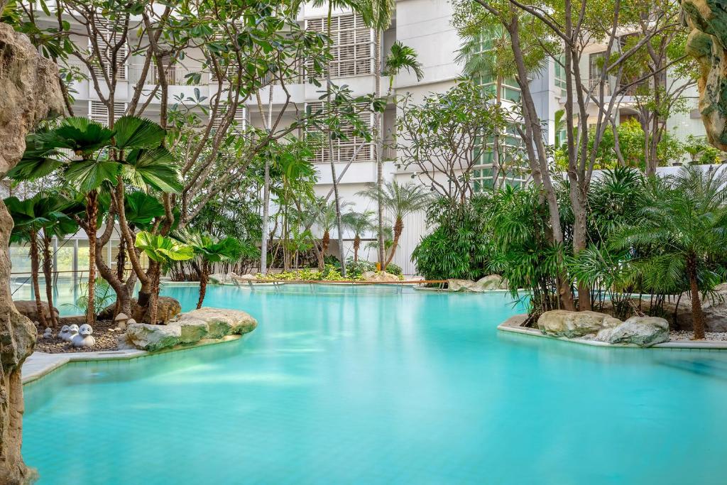 una piscina en el medio de un edificio con agua azul en Dusit Suites Hotel Ratchadamri, Bangkok, en Bangkok