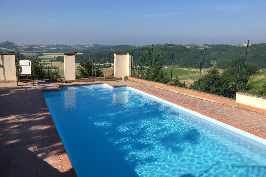 una piscina con agua azul en un patio trasero en La Fiaba del Monferrato, en Vignale
