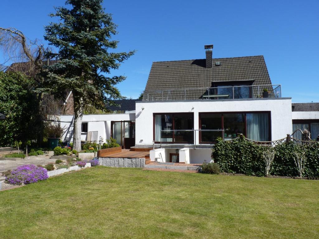 een groot wit huis met een tuin ervoor bij Ferienwohnung GOMO in Stockelsdorf