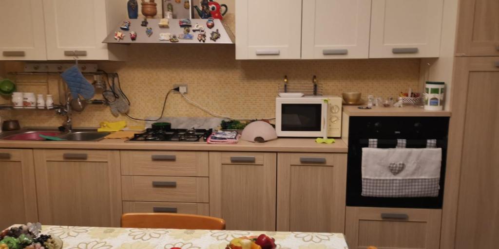 a kitchen with a stove and a microwave at Appartamento Nelli in Reggio di Calabria