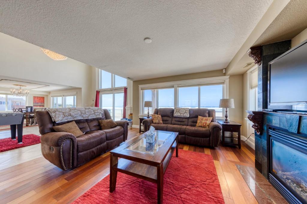 Una sala de estar con sofás y un televisor de pantalla plana. en Rockaway Beach Villa, en Rockaway Beach