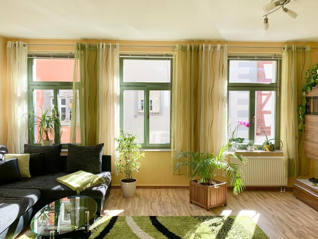 ein Wohnzimmer mit einem Sofa und einigen Fenstern in der Unterkunft Ferienwohnung in der Altstadt von Erfurt in Erfurt