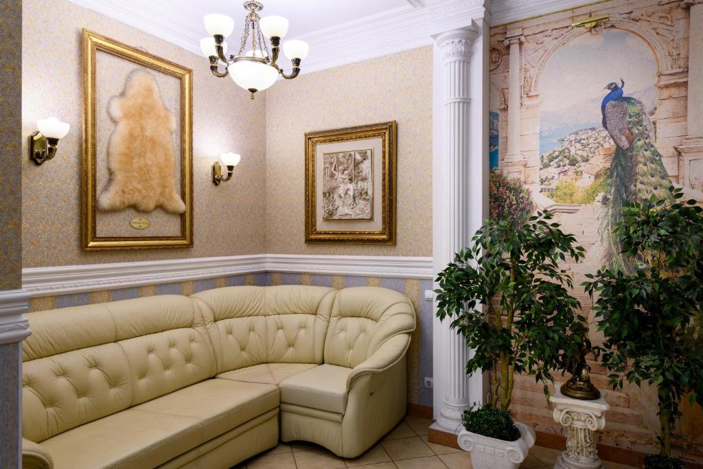 sala de estar con sofá y pinturas en las paredes. en Zolotoye Runo, en Novosibirsk